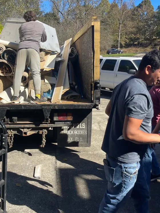 A Junk Brawlers crew loading carpet and scrap into the dump truck on a North Georgia job