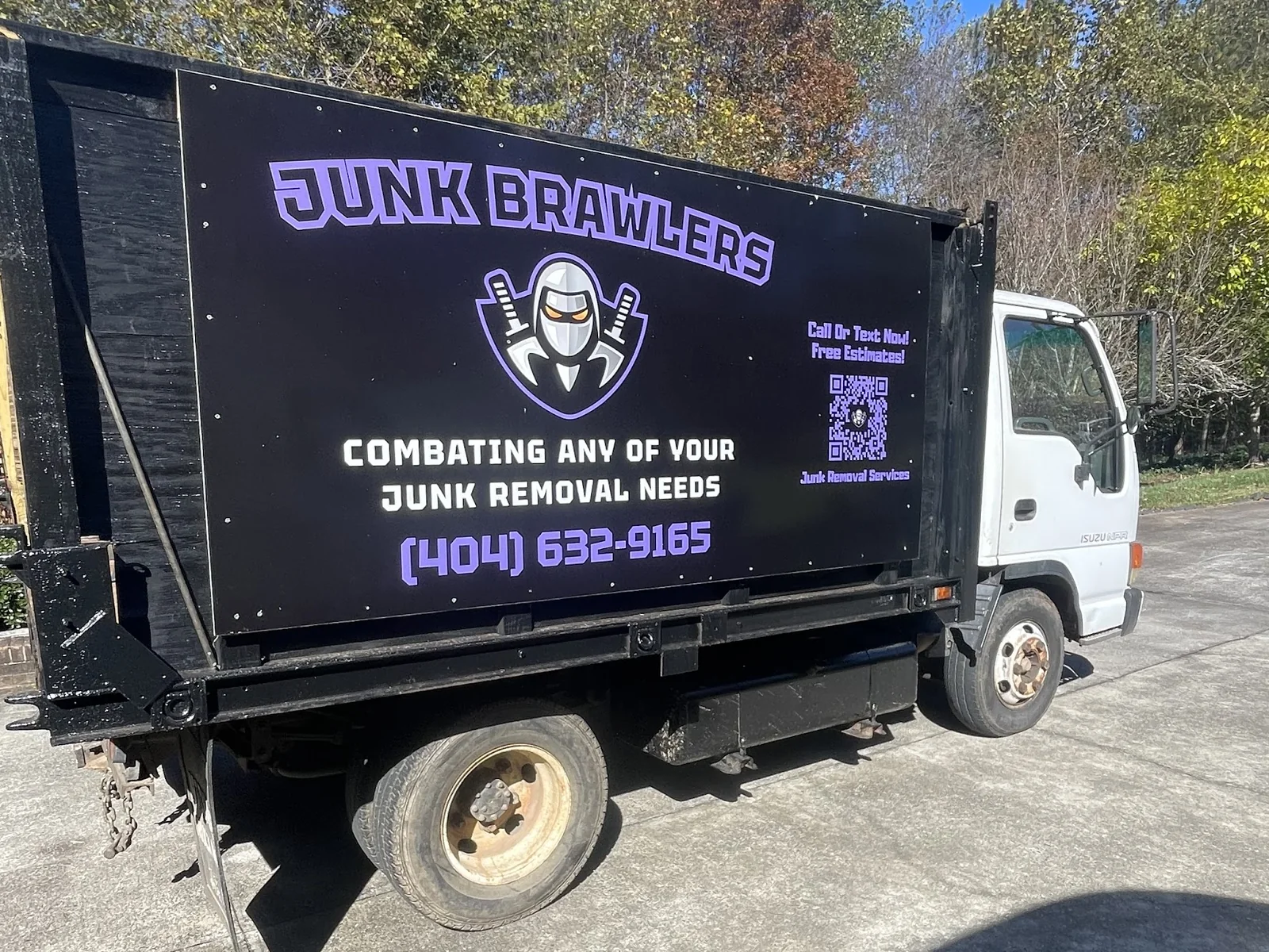 The Junk Brawlers dump truck with the company name and number on the side, parked in Dawson County