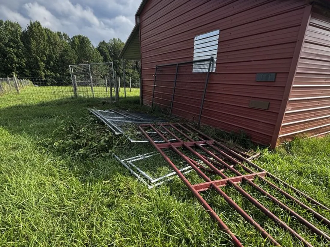 Fencing and pipe gates pulled down beside an outbuilding on a Ball Ground property
